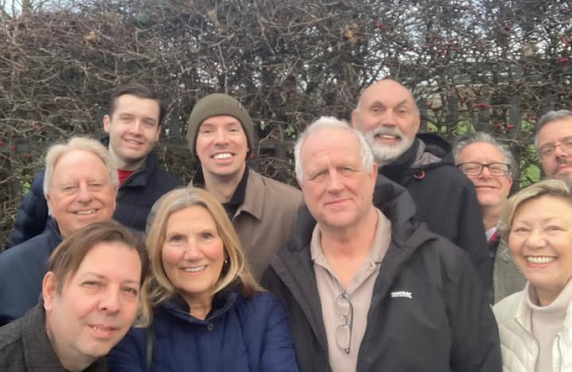A group of conservative voters gather together smiling at the camera