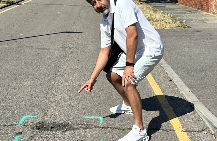 Cllr Sandu pointing out roads marked for repair. 