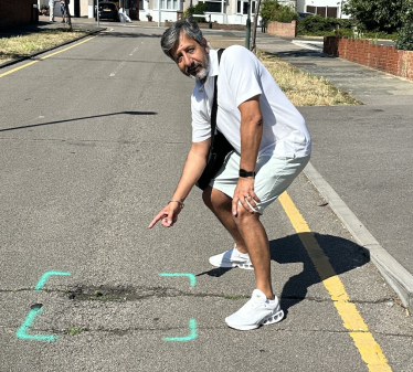 Cllr Sandu pointing out roads marked for repair. 